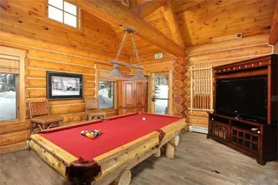 a living room with a pool table and a tv at Private 3 Bedroom Townhome Located In East Keystone With Access To A Firepit, Hot Tub, And Billiards in Keystone