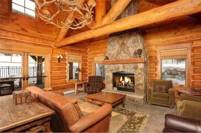 a living room with a fireplace in a log cabin at Private 3 Bedroom Townhome Located In East Keystone With Access To A Firepit, Hot Tub, And Billiards in Keystone