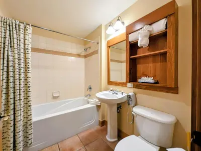 a bathroom with a tub and a toilet and a sink at Springs 8840 by SummitCove Lodging in Keystone