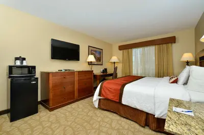 a hotel room with a bed and a flat screen tv at Best Western Denver Southwest in Lakewood
