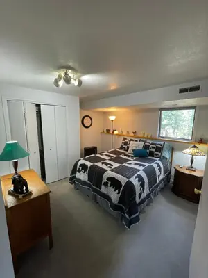 a bedroom with a black and white bed and a table at On the Divide in Bailey