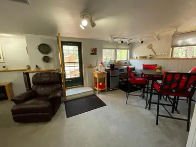 a living room with a table and red chairs at On the Divide in Bailey