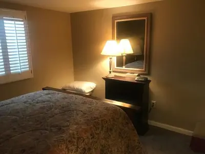 a bedroom with a bed and a mirror and a lamp at Denver Blue Bear Den 3BR 2BA & Spa in Denver