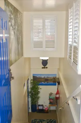 a hallway with a staircase with a window and a plant at Denver Blue Bear Den 3BR 2BA & Spa in Denver