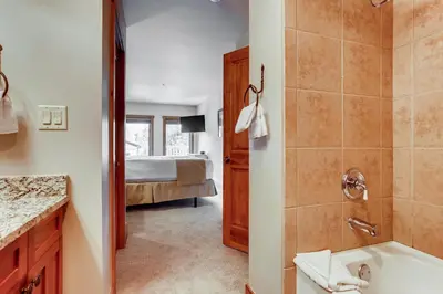 a bathroom with a shower and a bed in a room at Premier Red Hawk Lodge 2 Br-Walk To Slopes-Kids Ski Free Condo in Keystone