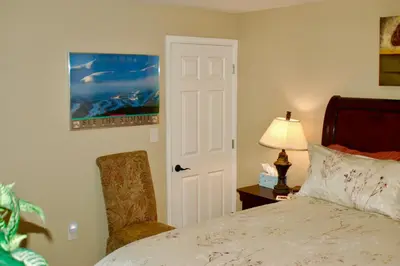 a bedroom with a bed and a chair and a lamp at Blue Bear Den 3BR 2BA DTC Private Apt Hot Tub in Denver