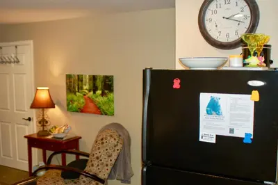 a black refrigerator in a room with a clock on the wall at Blue Bear Den 3BR 2BA DTC Private Apt Hot Tub in Denver