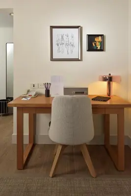 a wooden desk with a white chair and a table at Warwick Denver in Denver