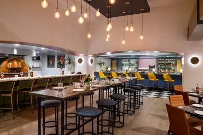 a restaurant with tables and chairs and a bar at Warwick Denver in Denver