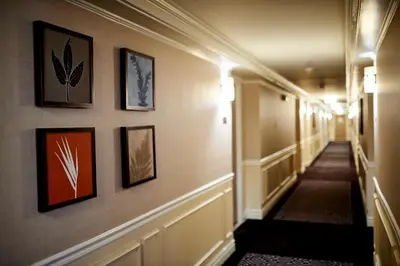 a hallway of a hotel with pictures on the walls at Warwick Denver in Denver