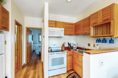 a kitchen with wooden cabinets and a white stove top oven at Timber Ridge 504B in Silverthorne
