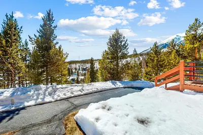 a snow covered road with a bench and trees at Timber Ridge 504B in Silverthorne