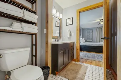 a bathroom with a toilet and a sink and a bed at Mountains & Main Street in Frisco