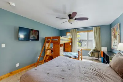 a bedroom with a bed and a bunk bed with a ceiling fan at Mountains & Main Street in Frisco