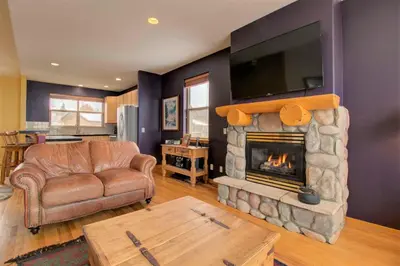 a living room with a couch and a fireplace with a television at 97A Exceptional Views, 4 BR, Central Location in Silverthorne