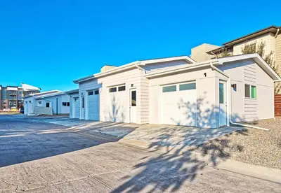 a row of white buildings in a parking lot at Beautiful 3 Bedroom Townhouse in Old Town North, Brewery District in Fort Collins