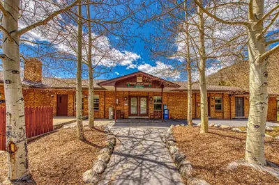 a brick house with trees in front of it at Straight Creek Sanctuary in Dillon