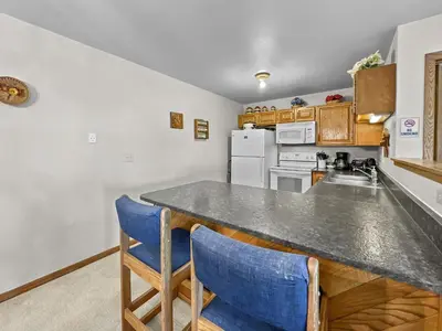 a kitchen with a counter and two blue chairs at Bb103 Buffalo Village 2Br 2Ba Condo in Silverthorne