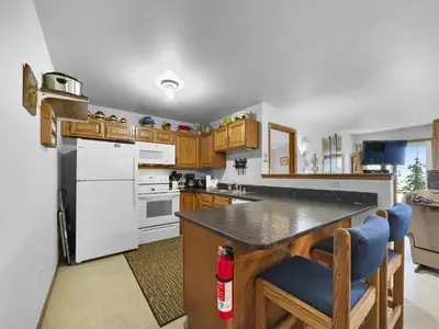 a kitchen with a white refrigerator and wooden cabinets at Bb103 Buffalo Village 2Br 2Ba Condo in Silverthorne