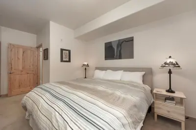 a bedroom with a bed and a table with a lamp at Trailhead Lodges Building 401 Unit 422 in Winter Park