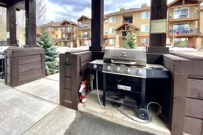 a outdoor kitchen with a grill on a patio at Trailhead Lodges Building 401 Unit 422 in Winter Park