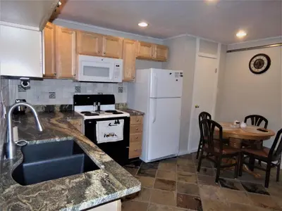 a kitchen with a white refrigerator and a table at Treehouse 2 bed 2 bath C THWC in Silverthorne