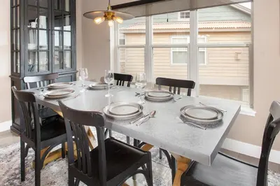 a dining room with a table with plates and glasses at Rendezvous 47 Lookout Point in Fraser