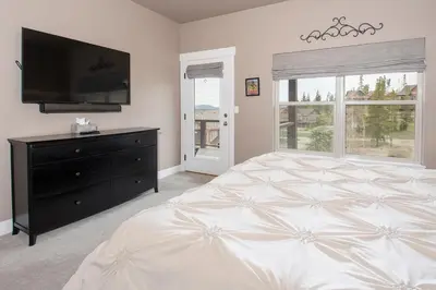 a bedroom with a large bed and a flat screen tv at Rendezvous 47 Lookout Point in Fraser