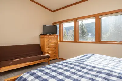 a bedroom with a bed and a couch and windows at 1320 Tennis Townhome Townhouse in Keystone