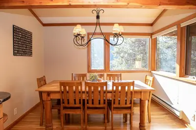 a dining room with a table and chairs and a chandelier at 1320 Tennis Townhome Townhouse in Keystone
