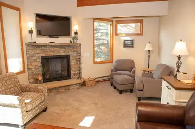 a living room with a fireplace and a tv at 1320 Tennis Townhome Townhouse in Keystone