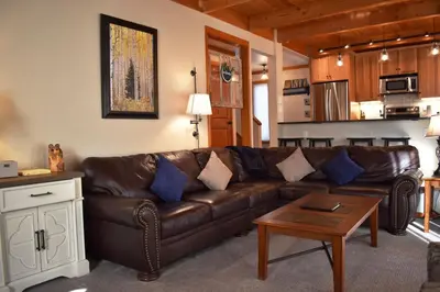 a living room with a brown leather couch and a table at 1320 Tennis Townhome Townhouse in Keystone
