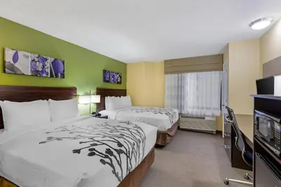 a hotel room with two beds and a flat screen tv at Sleep Inn Denver Tech Center in Greenwood Village