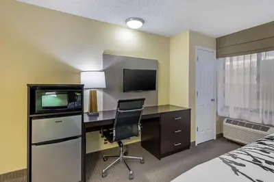 a hotel room with a desk with a television and a bed at Sleep Inn Denver Tech Center in Greenwood Village