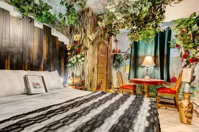 a bedroom with a bed and a large tree at The Oasis on Eisenhower in Loveland