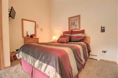 a bedroom with a large bed and a mirror at Dd402E Buffalo Village Studio Condo in Silverthorne