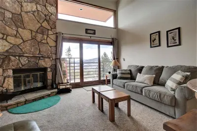 a living room with a couch and a stone fireplace at Dd402E Buffalo Village Studio Condo in Silverthorne