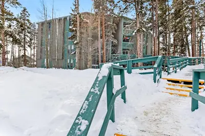 a snow covered walkway with benches and a building at Lodgepole Treehouse & Treehouse Serenity in Silverthorne