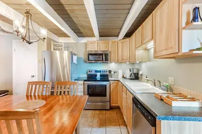 a kitchen with wooden cabinets and a wooden table at Lodgepole Treehouse & Treehouse Serenity in Silverthorne