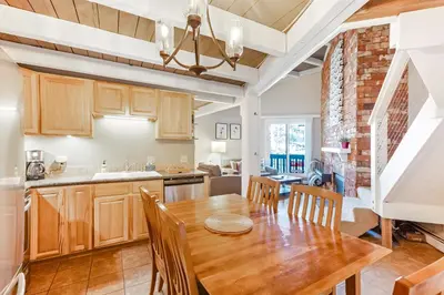 a kitchen and dining room with a wooden table and chairs at Lodgepole Treehouse & Treehouse Serenity in Silverthorne