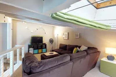 a living room with a couch and a television at Lodgepole Treehouse & Treehouse Serenity in Silverthorne