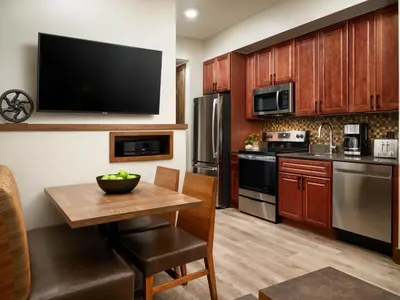 a kitchen with wooden cabinets and a wooden table at Hyatt Vacation Club at The Ranahan in Breckenridge