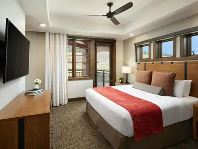 a bedroom with a large bed and a flat screen tv at Hyatt Vacation Club at The Ranahan in Breckenridge
