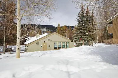 a snow covered yard with a house in the background at 1182 Flying Dutchman condo in Keystone