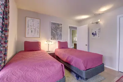 two beds in a room with pink sheets at CC19 Chateau Claire condo in Dillon