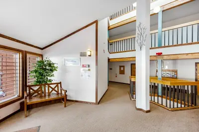 a room with a staircase and a table and bench at Buffalo Village in Silverthorne