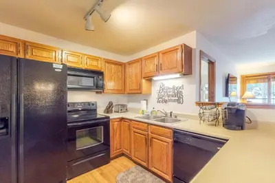 a kitchen with wooden cabinets and a black refrigerator at Buffalo Village in Silverthorne
