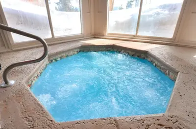 a hot tub in a room with a window at Buffalo Village in Silverthorne