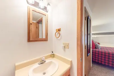 a bathroom with a sink and a mirror and a bed at Buffalo Village in Silverthorne
