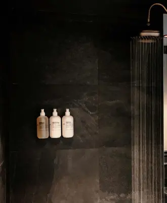 three white bottles sitting on a shelf in a bathroom at Gravity Haus Denver in Denver